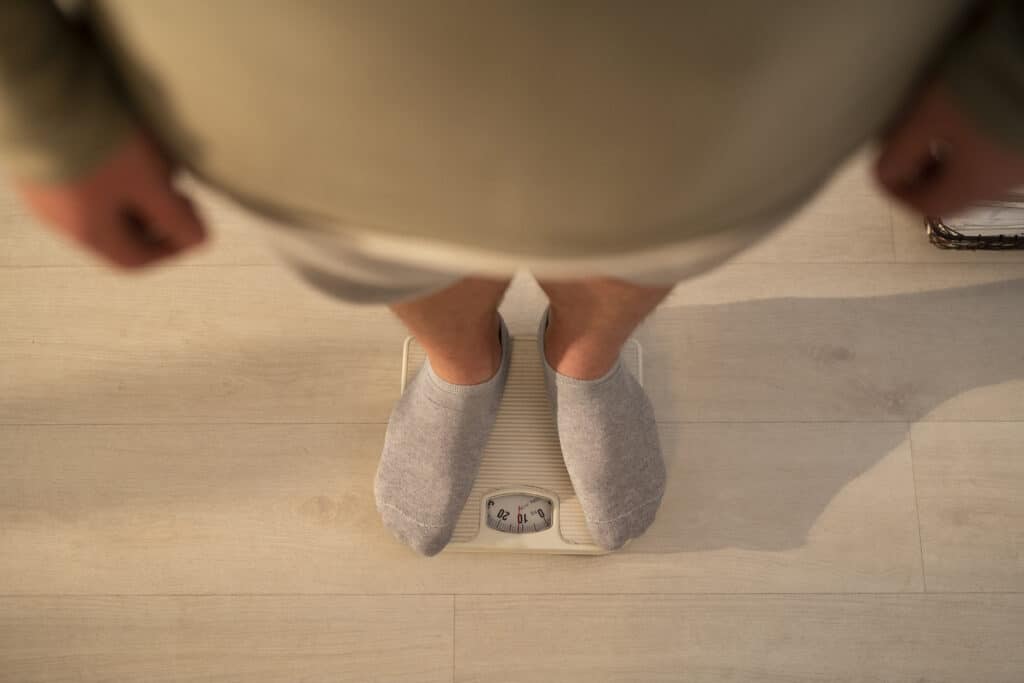 Personne debout sur une balance, surveillant son poids corporel