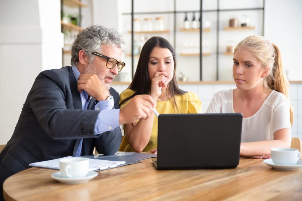 Réunion professionnelle autour d'un ordinateur pour une discussion collaborative