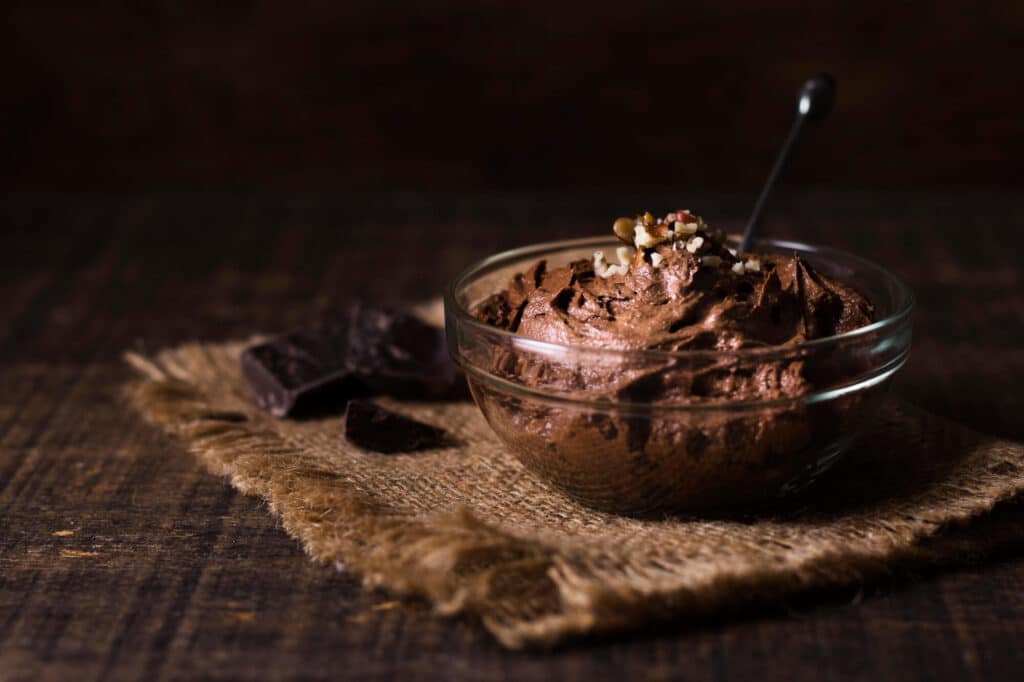 Mousse au chocolat onctueuse garnie de noix sur fond rustique